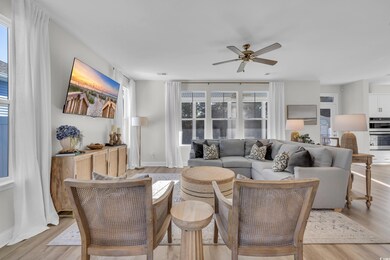 Living room with ceiling fan and light wood-type f