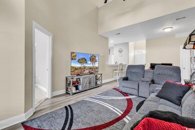 Living room with a high ceiling and light hardwood