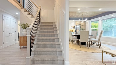 Stairs with wood finished floors, recessed lighting, and a chandelier