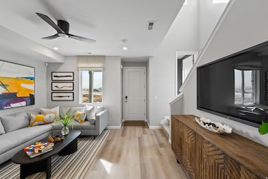 Living area featuring light wood-type flooring, a ceiling fan, stairs, and recessed lighting
