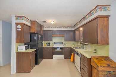 Kitchen featuring white appliances, light countertops, and a textured ceiling