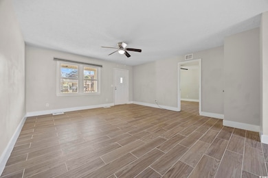 Unfurnished room featuring wood finish floors and a ceiling fan