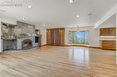Unfurnished living room featuring a fireplace, light wood-type flooring, recessed lighting, and a chandelier