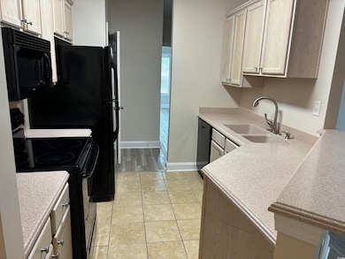 Kitchen featuring light tile patterned floors, sin