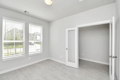 Experience the perfect blend of sophistication and warmth in this home office, boasting elegant wood-look tile flooring and flooded with natural light from expansive windows and French doors. Sample photo of completed home with similar floor plan. Actual colors and selections may vary.
