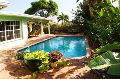 Large pool surrounded by Tropical Landscaping.