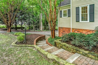 Charming stone walk leads from the front door to the paved driveway.
