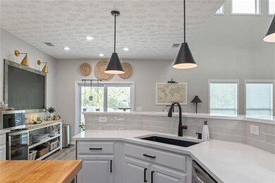 Kitchen with decorative light fixtures, sink, tast