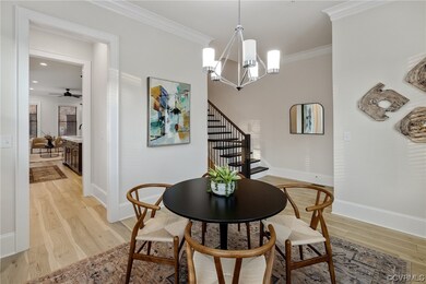 Sunlit filled Dining room with chandelier, Luxury Vinyl Plank flooring and crown molding.