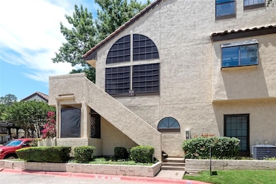 View of building exterior featuring central AC uni