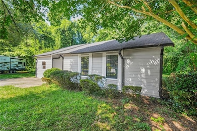 View of side of home featuring a yard and roof with shingles