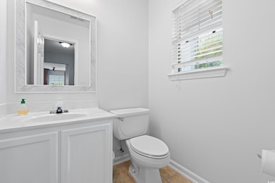 Half bath with toilet, vanity, visible vents, tile