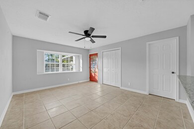 A well-appointed living room features plenty of space for a variety of furniture arrangements. A large front-facing window allows natural light to illuminate the room.