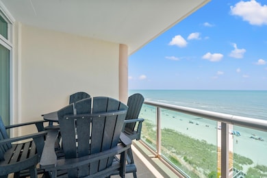 Balcony with view of water and beach and outdoor dining area