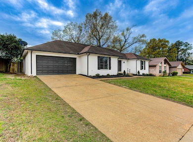Ranch-style home featuring driveway, a front yard,