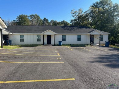 Ranch-style home with board and batten siding, uncovered parking, and roof with shingles