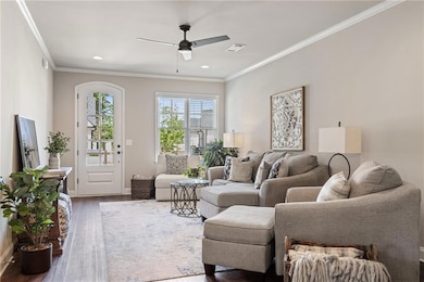 Living room with crown molding, dark wood-type flo