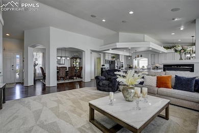 Living room with carpet, vaulted ceiling, built in