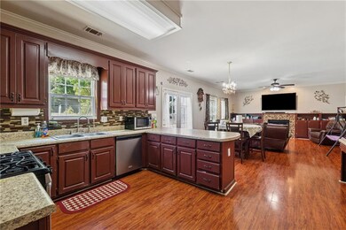 Kitchen with stainless steel appliances, a sink, plenty of natural light, light countertops, and ornamental molding