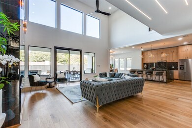 Living room featuring light wood-style floors, recessed lighting, a high ceiling, and a ceiling fan