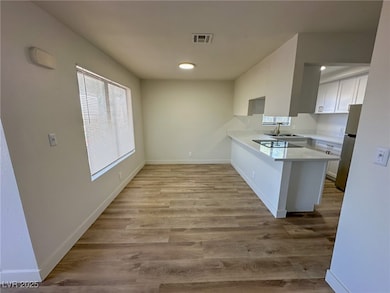 Kitchen featuring a peninsula, light countertops,