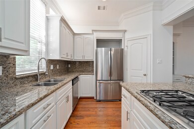 A view of the kitchen with stainless steel appliances, large pantry and island with cooktop