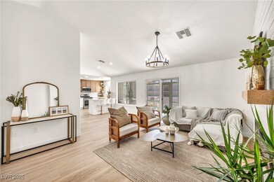 Living area with a chandelier, light wood-style fl