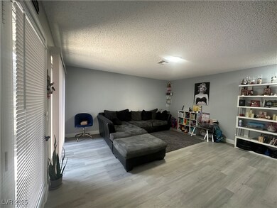 Living room with a textured ceiling and wood finished floors