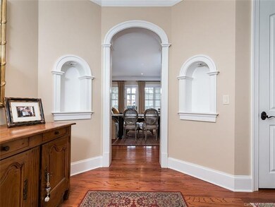 wide and open foyer has built in niches, a coat cl