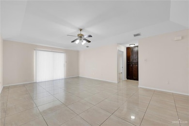 Spare room with ceiling fan and light tile patterned floors