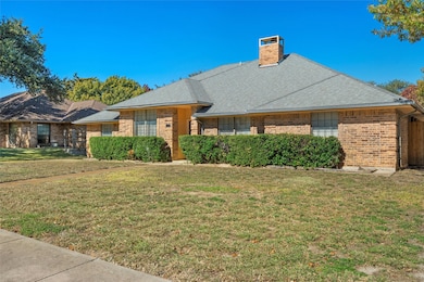 Ranch-style house with a front lawn, a chimney, a shingled roof, and brick siding