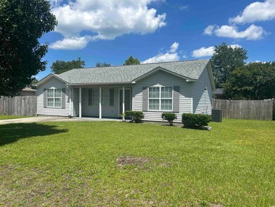 Rear view of property with a shingled roof and covered porch