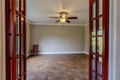 Spare room with ornamental molding, ceiling fan, french doors, and dark tile patterned floors