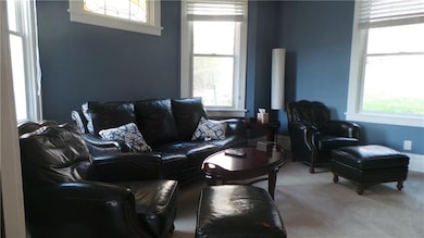 Living room has crown molding and wooden blinds.  