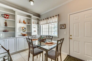 Dining area with ornamental molding, light tile pa