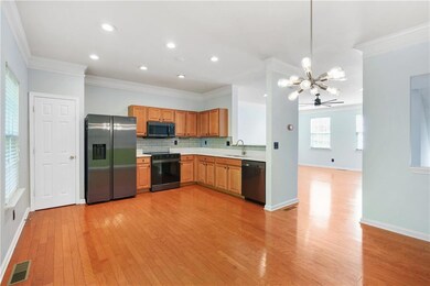 Kitchen featuring stainless steel fridge with ice dispenser, black range with electric stovetop, dishwasher, a chandelier, and a sink