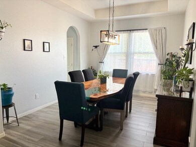 Bright dining room with a modern light fixture, se