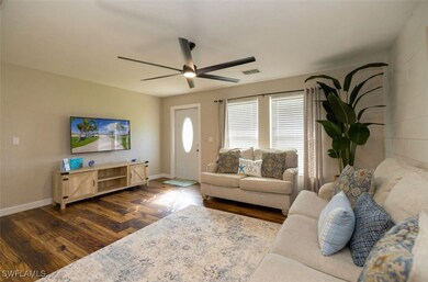Living room featuring ceiling fan and dark hardwoo
