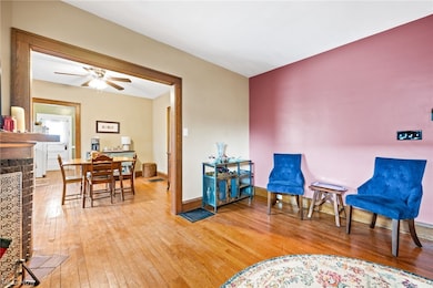 Up unit living room featuring a decorative fireplace, ceiling fan, and light hardwood / wood-style floors
