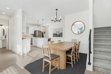 Dining room featuring stairway, light wood-type flooring, a chandelier, and recessed lighting