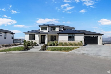 View of front of property with a standing seam roof, stone siding, a metal roof, and an attached garage
