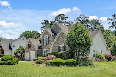 View of front of home with a front yard, a garage, and a shingled roof