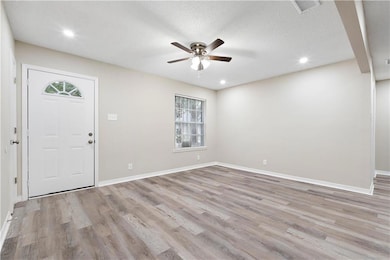Foyer featuring light hardwood / wood-style flooring, ceiling fan, and a textured ceiling