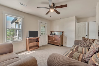 Living room with carpet and ceiling fan
