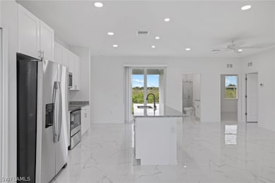 Kitchen with stainless steel fridge, range, light