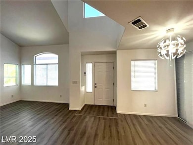 Entryway featuring a chandelier, dark wood-style f