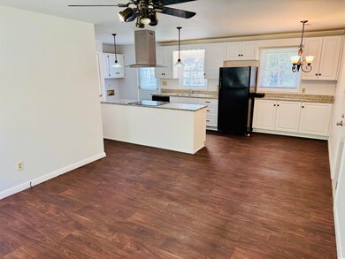 Kitchen with a sink, white cabinets, island exhaus