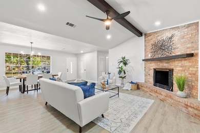 Living room with light wood-type flooring, a fireplace, recessed lighting, a chandelier, and ceiling fan