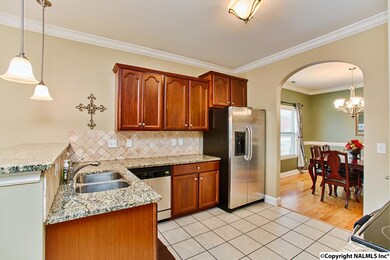 Kitchen features granite counters, stone backsplash, stainless steel appliance package and convenient access to both the formal dining room and breakfast room.