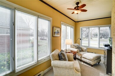 Side porch off of living room with beadboard ceiling and lots of windows